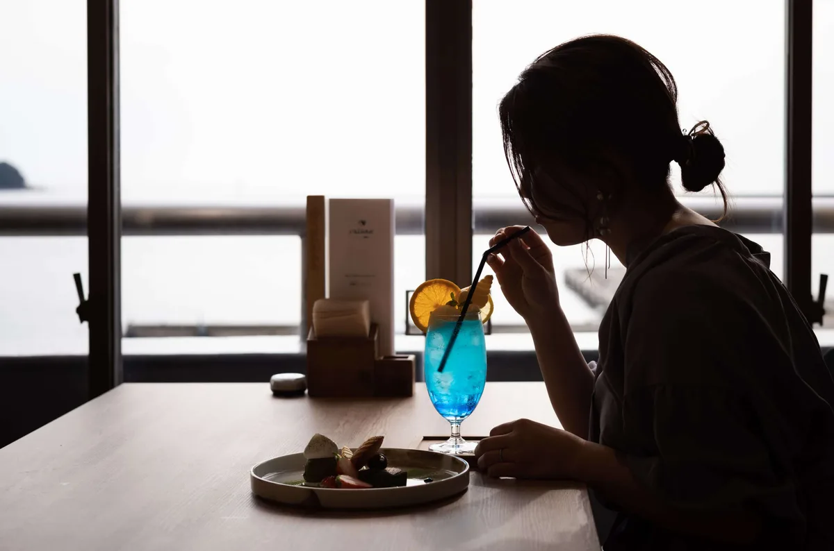 メールブリヤンの窓辺で飲み物を楽しむ様子